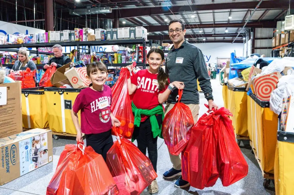 A family volunteering together and showing the presents they are about to give.