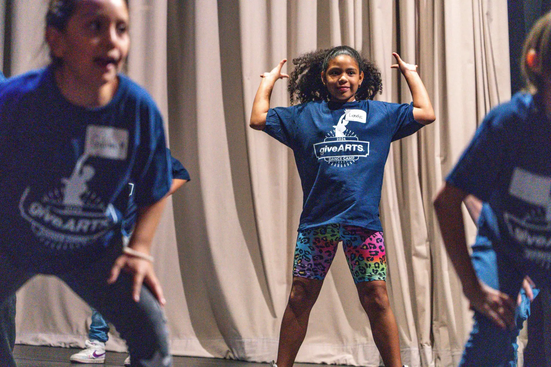 A group of giveARTS attendees smiling and stretching.