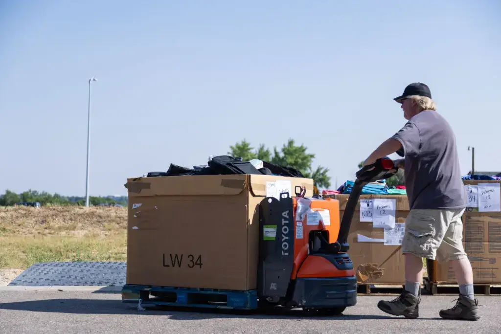 A man moving a batch of bulk donations.